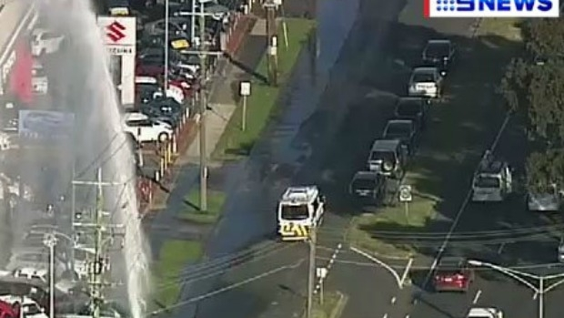 Article image for Crash ruptures fire hydrant, sending water shooting into the air