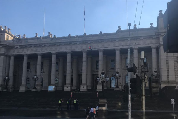 Article image for Protester hanging off the roof of State Parliament