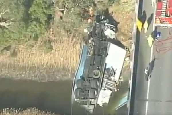 Article image for Driver critical after truck hits barriers, rolls off a bridge on the Bass Highway