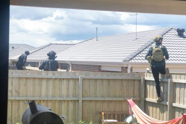 Article image for Woman finds armed police officers in her backyard executing a warrant on her neighbour