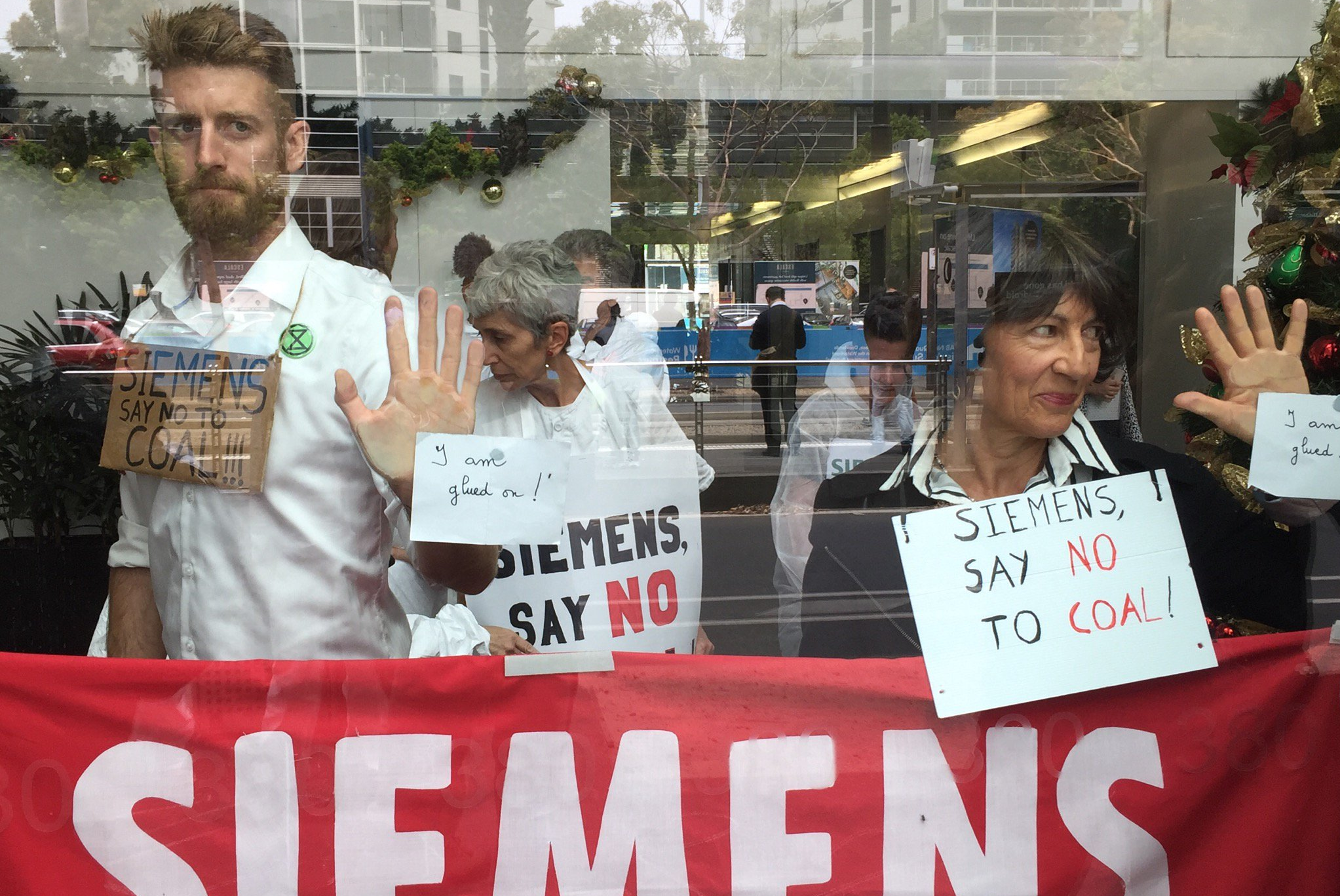 Activists glue themselves to Siemens office in protest against tech giant's  Adani mine contract