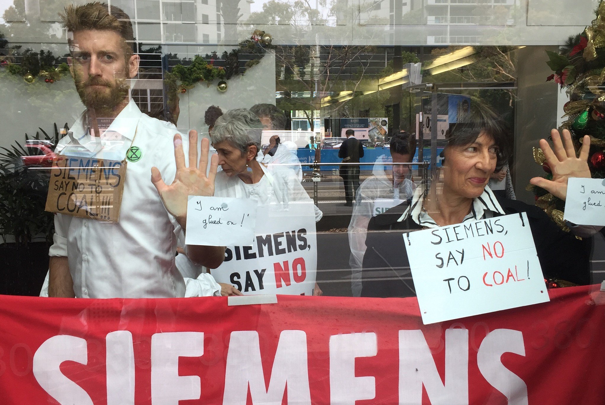 Article image for Activists glue themselves to Siemens office in protest against tech giant’s Adani mine contract