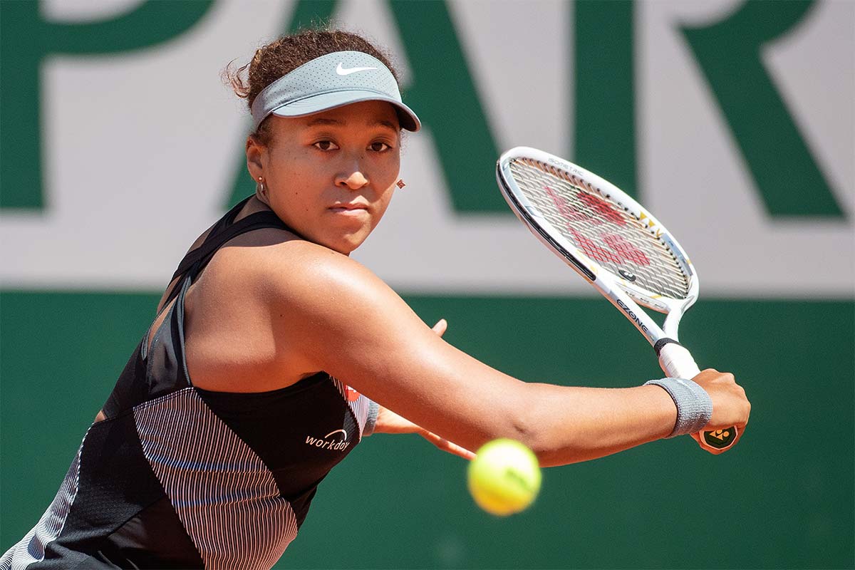 Naomi Osaka swings a tennis racquet at a ball at Roland Garros