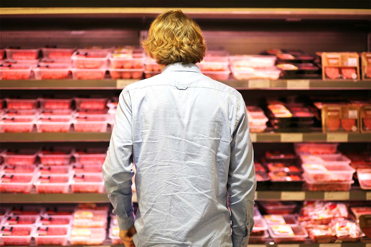 Male purchasing red meat at supermarket