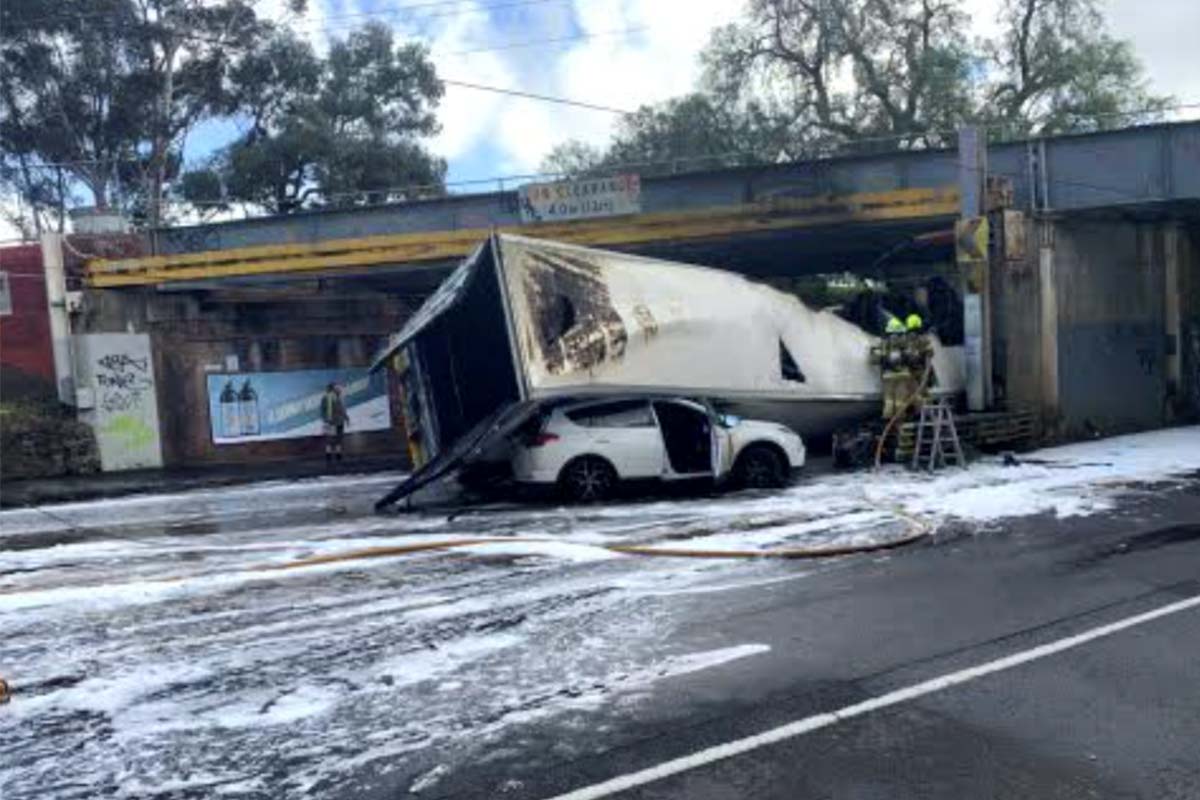 Article image for Truck collides with Essendon rail bridge, catches fire and rolls on a car