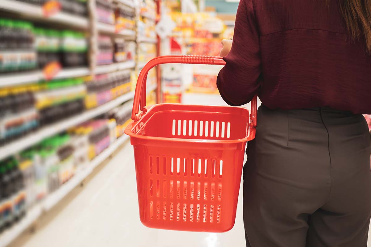 Woman with basket in supermarket