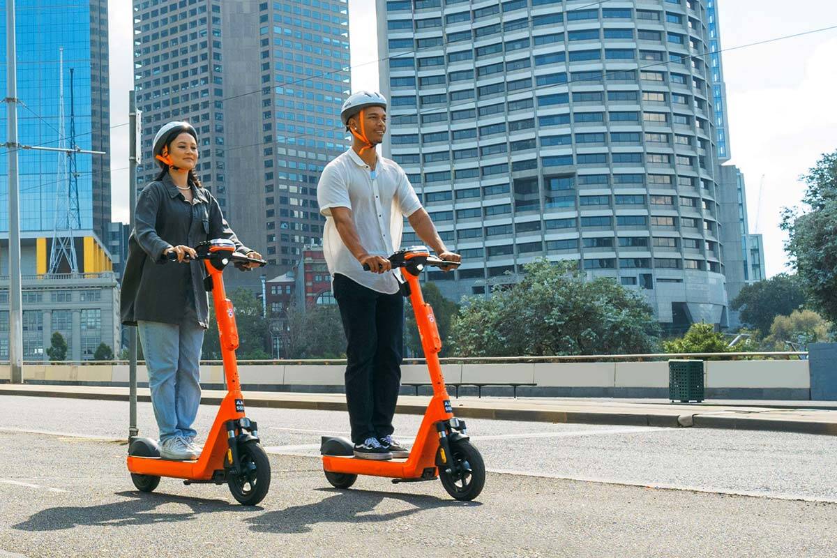 two people riding electric scooters